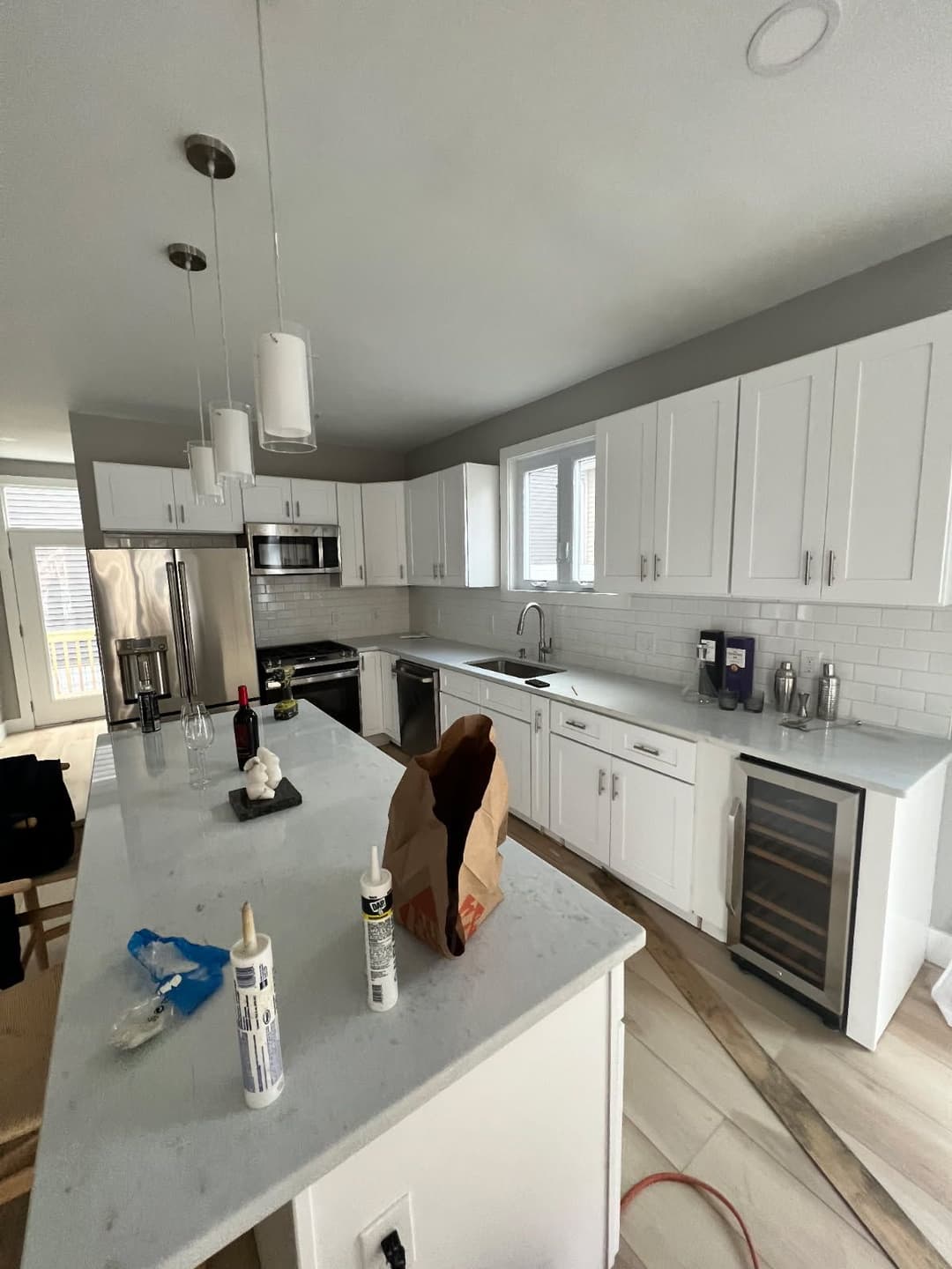 Modern kitchen with white cabinetry, stainless steel appliances, and a gray accent wall.