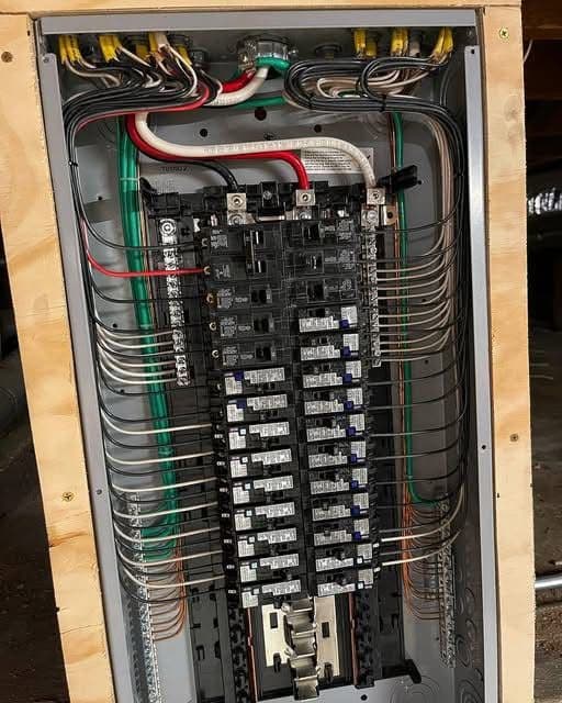 Close-up of a residential electrical panel with breakers and wiring connections visible.