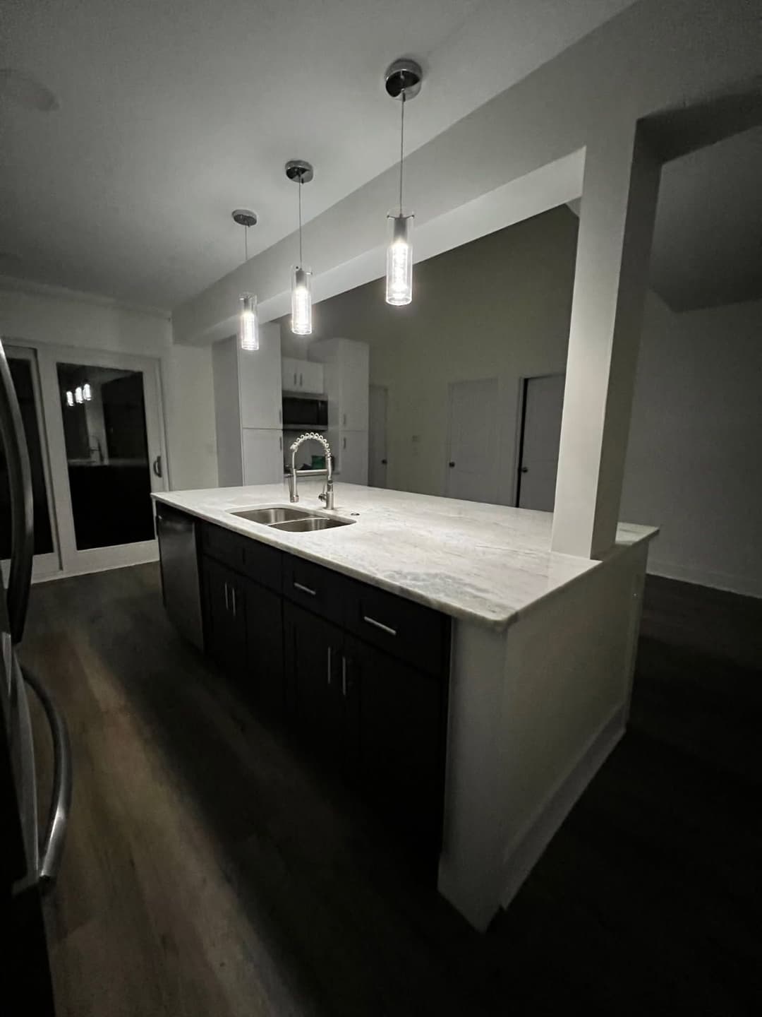 Modern kitchen with a central island, pendant lighting, and stainless steel appliances.